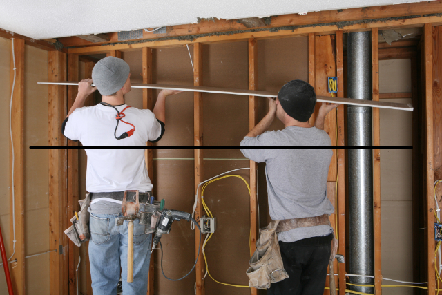 Bend drywall workers installing drywall